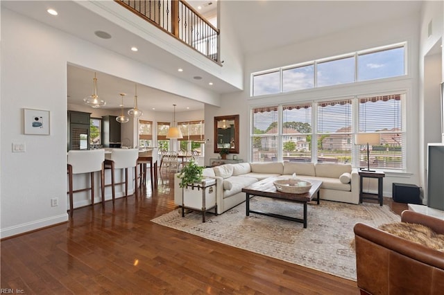 living area featuring baseboards, a high ceiling, and wood finished floors