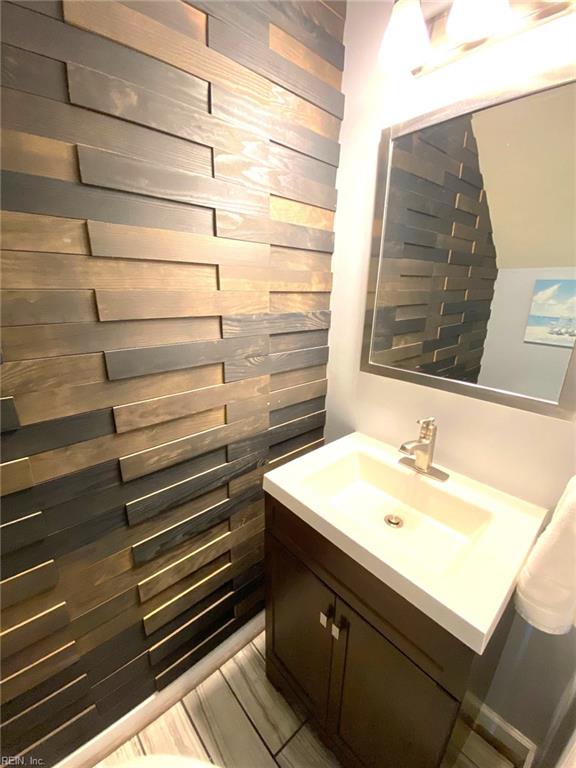 bathroom featuring vanity and wooden walls