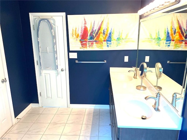 bathroom with double vanity, baseboards, and a sink