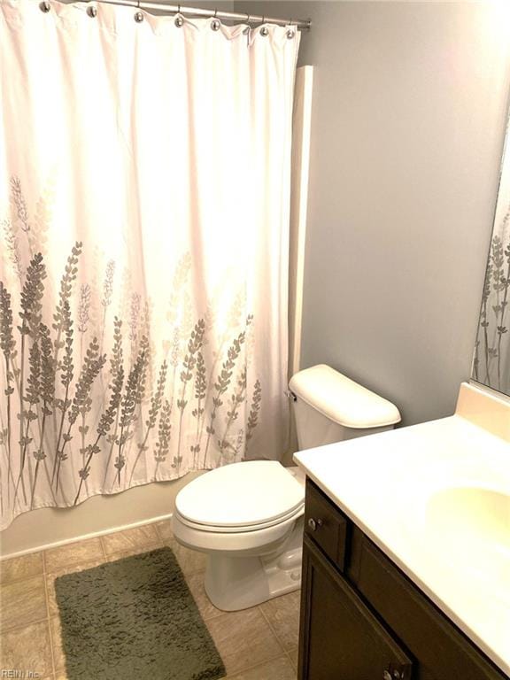 bathroom with toilet, a shower with curtain, tile patterned floors, and vanity