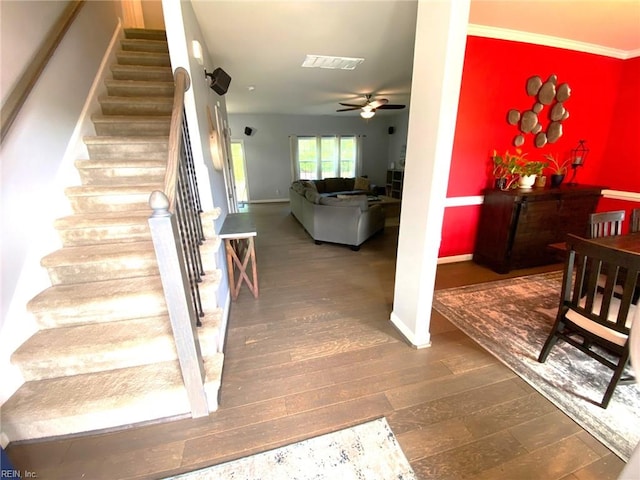 stairway with a ceiling fan, baseboards, visible vents, and wood finished floors