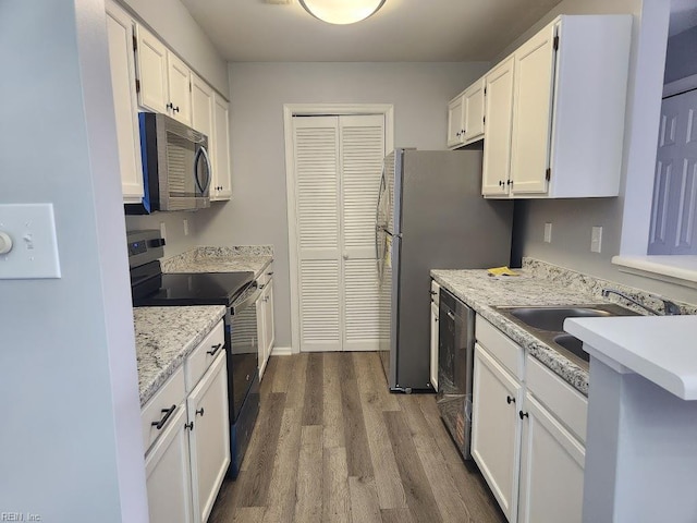 kitchen with white cabinets, light countertops, appliances with stainless steel finishes, and dark wood-type flooring