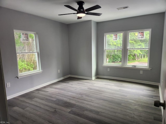 spare room with visible vents, a ceiling fan, baseboards, and wood finished floors