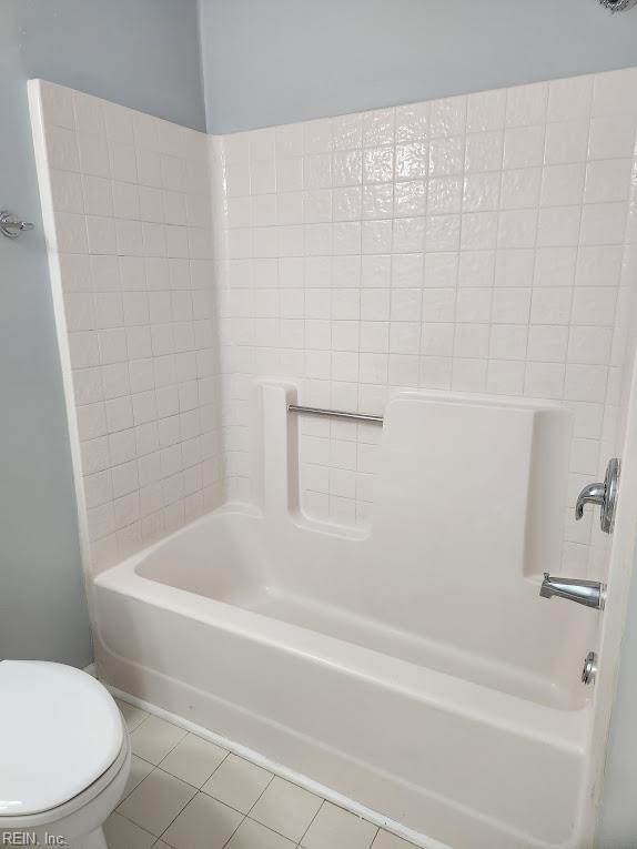 bathroom with tile patterned flooring, shower / bathtub combination, and toilet