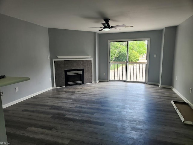 unfurnished living room featuring baseboards, a high end fireplace, dark wood-style flooring, and ceiling fan