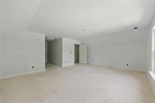 additional living space featuring vaulted ceiling and baseboards