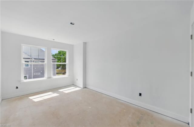 unfurnished room featuring unfinished concrete flooring and baseboards