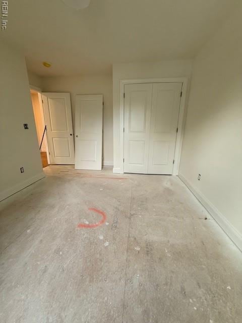 unfurnished bedroom with baseboards and a closet
