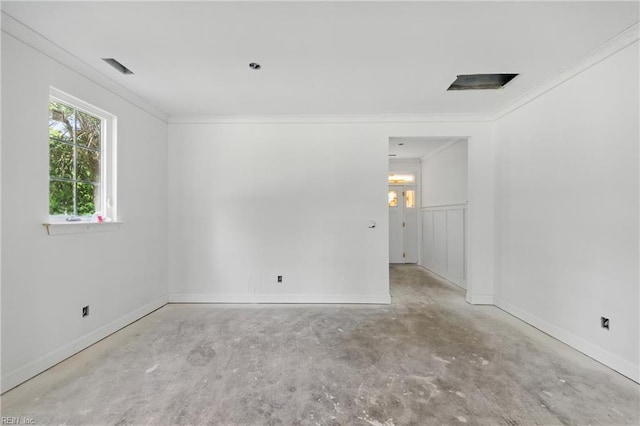 unfurnished room featuring unfinished concrete floors, crown molding, and baseboards