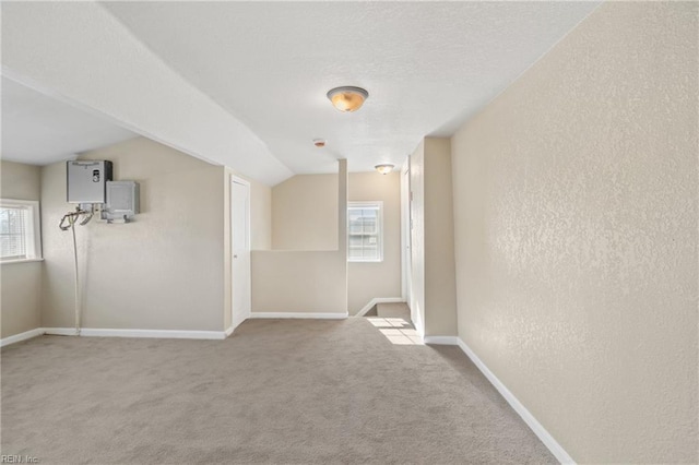 2509 Tidewater Dr, Norfolk, VA 23504 - carpeted empty room featuring healthy amount of natural light, a textured wall, lofted ceiling, baseboards, and a textured ceiling