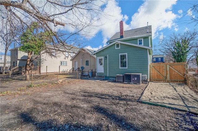 2509 Tidewater Dr, Norfolk, VA 23504 - rear view of property with a gate, a chimney, and central AC unit