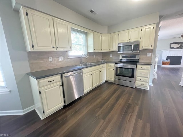 1304 Fernham Ln, Chesapeake, VA 23322 - kitchen featuring dark wood-style flooring, dark countertops, a sink, stainless steel appliances, and visible vents