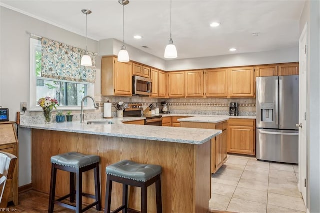 kitchen featuring decorative backsplash, appliances with stainless steel finishes, light stone countertops, a sink, and a peninsula