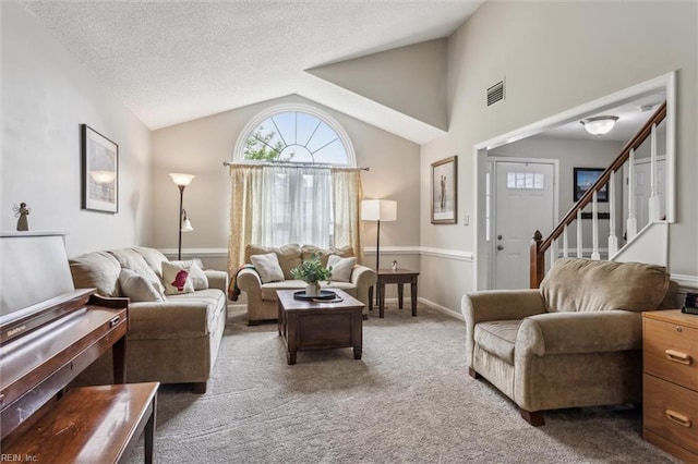 living area with visible vents, carpet, a healthy amount of sunlight, and vaulted ceiling