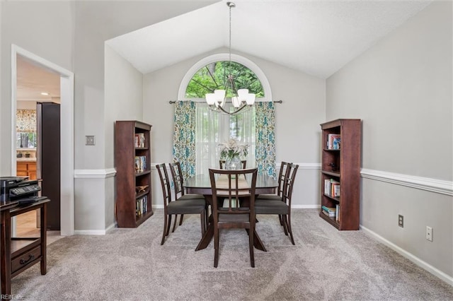 dining space featuring an inviting chandelier, carpet floors, baseboards, and lofted ceiling