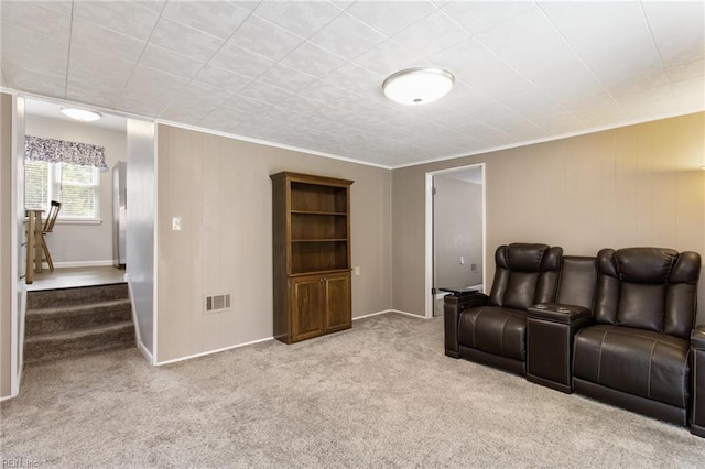 carpeted living room featuring visible vents, baseboards, and crown molding