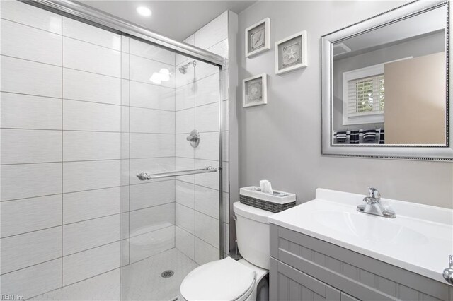 full bathroom featuring vanity, a stall shower, and toilet