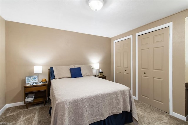 bedroom featuring two closets, baseboards, and carpet