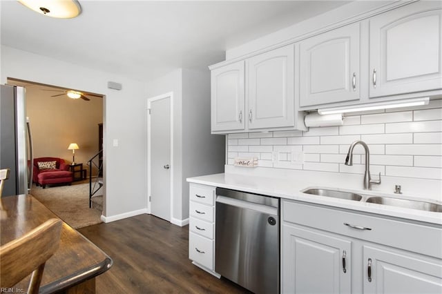 kitchen with a sink, light countertops, dark wood finished floors, stainless steel appliances, and tasteful backsplash