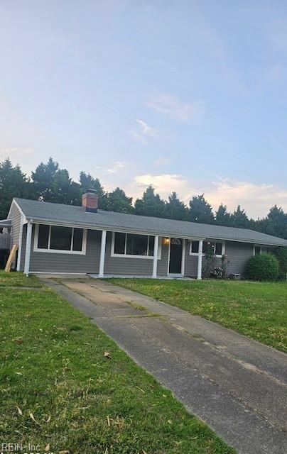 view of front of home with a front yard and a chimney