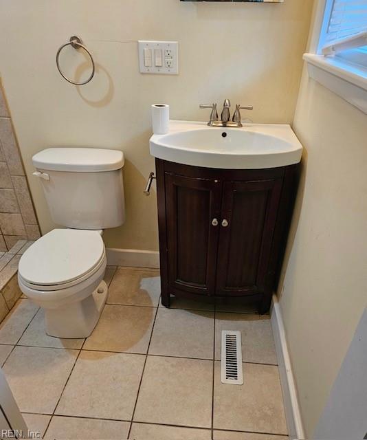 bathroom with toilet, visible vents, tile patterned flooring, and vanity