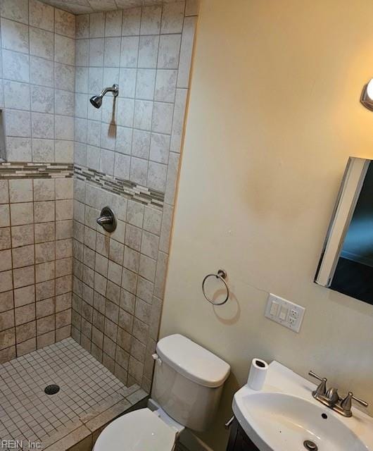 full bath featuring a sink, a stall shower, and toilet