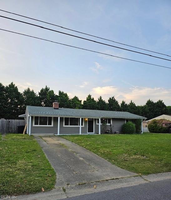 single story home with a chimney, fence, a front yard, and concrete driveway