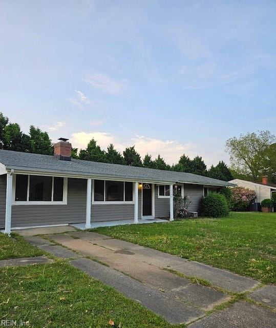 single story home with a chimney and a front yard
