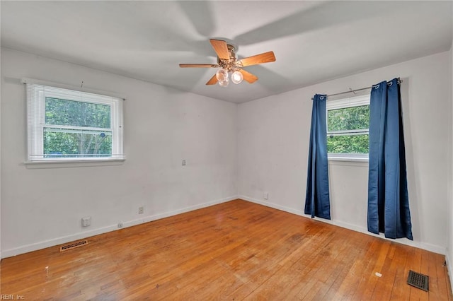 unfurnished room with baseboards, ceiling fan, light wood-style flooring, and visible vents