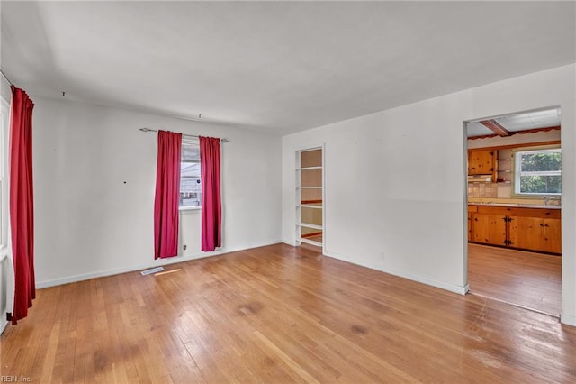 spare room with baseboards, visible vents, and hardwood / wood-style floors
