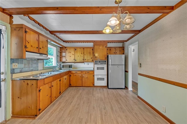 kitchen with beam ceiling, light wood-style floors, under cabinet range hood, a notable chandelier, and stainless steel appliances
