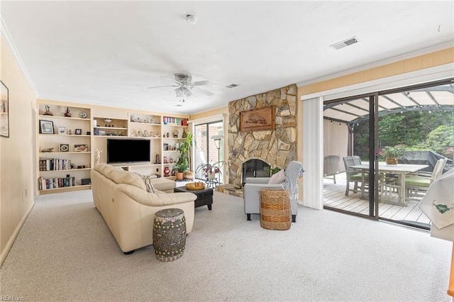 living area featuring ceiling fan, visible vents, a fireplace, ornamental molding, and carpet flooring