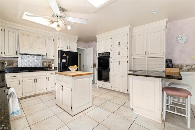 kitchen featuring light tile patterned flooring, a ceiling fan, white cabinetry, and black appliances