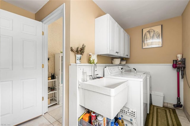 laundry area featuring cabinet space, a sink, light tile patterned floors, and washing machine and clothes dryer