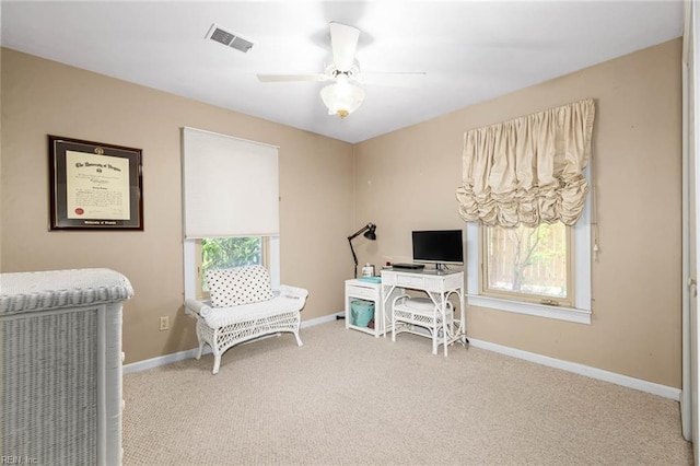 carpeted office space featuring baseboards, a ceiling fan, and visible vents