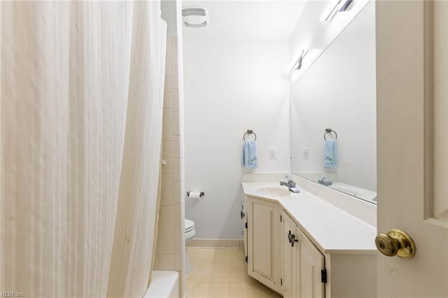 bathroom with vanity, baseboards, tile patterned floors, and toilet
