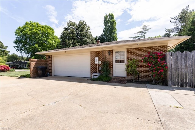 single story home featuring brick siding, fence, concrete driveway, an attached garage, and entry steps