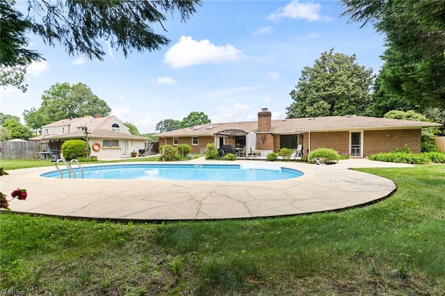 pool with a lawn, a patio, and fence