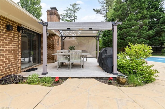 view of patio / terrace with grilling area, a deck, outdoor dining area, and an outdoor pool