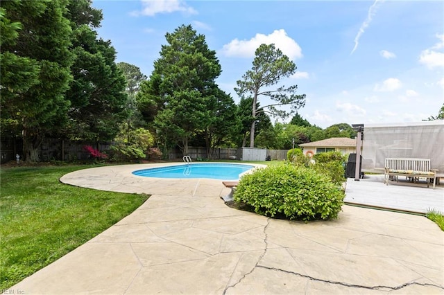 view of swimming pool featuring a deck, a fenced backyard, a fenced in pool, a patio area, and a yard
