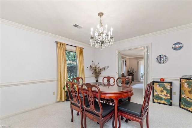 carpeted dining room featuring visible vents, ornamental molding, a wainscoted wall, and a chandelier