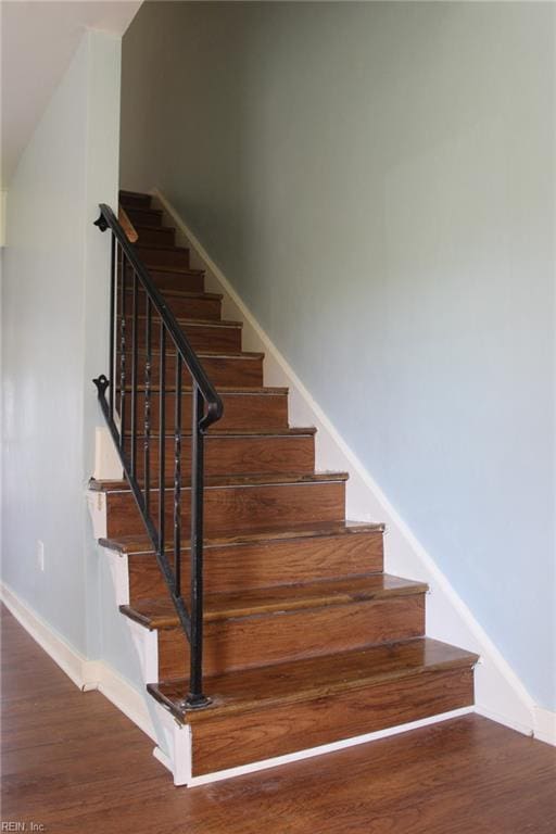 stairway featuring baseboards and wood finished floors