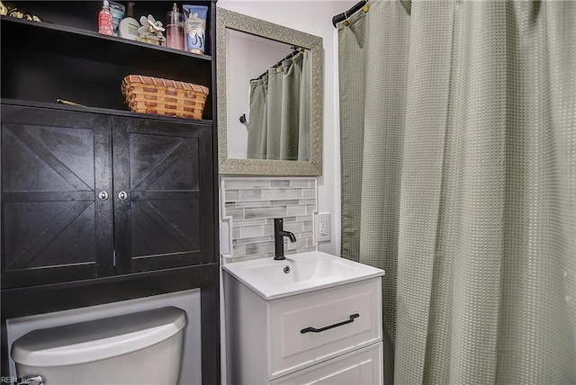 full bath featuring vanity, decorative backsplash, and toilet