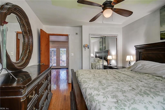 bedroom with a closet, a ceiling fan, wood-type flooring, and french doors