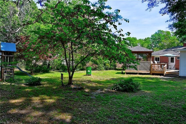 view of yard with a gazebo, a playground, and a wooden deck