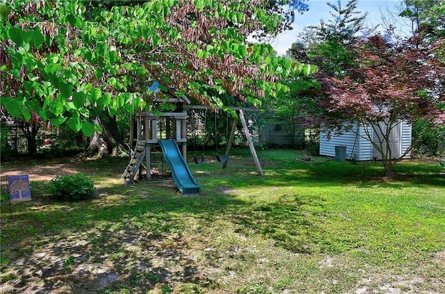view of yard with a playground, a storage unit, and an outbuilding