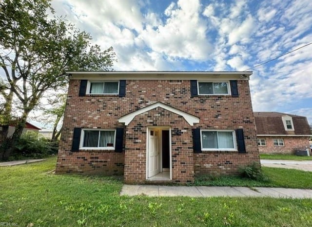 view of front facade featuring brick siding and a front lawn
