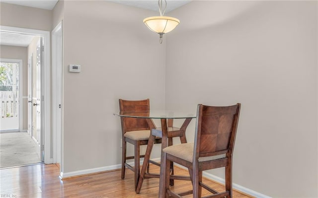 dining room with baseboards and wood finished floors