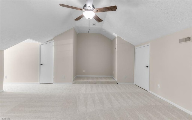 additional living space with ceiling fan, visible vents, carpet floors, baseboards, and lofted ceiling