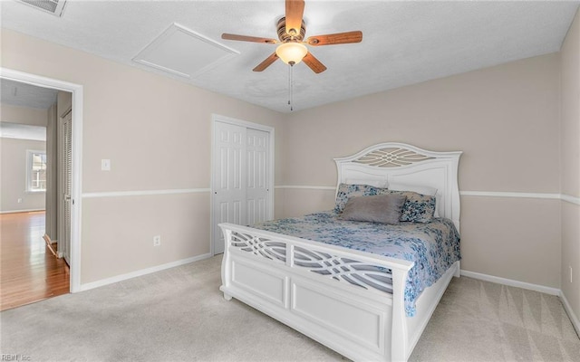 bedroom featuring baseboards, attic access, visible vents, and light carpet